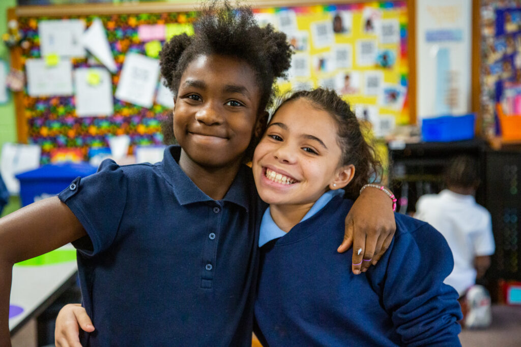 Two students smile for the camera.